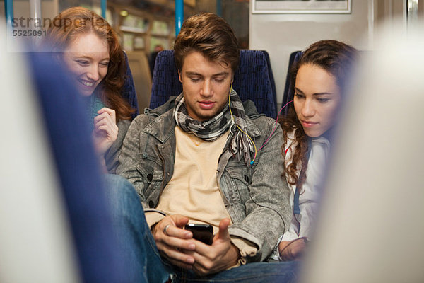 Drei junge Freunde  die im Zug unterwegs sind und Musik hören.