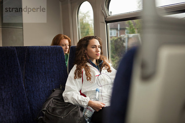 Zwei junge Frauen  die im Zug unterwegs sind