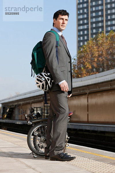 Mitte Erwachsenen Geschäftsmann Durchführung Falt Fahrrad am Bahnsteig