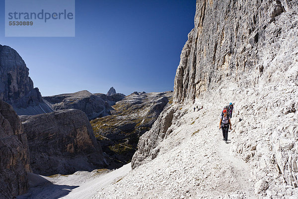 Wanderer im Alpinisteig  hinten die Drei Zinnen  Hochpustertal  Sexten  Dolomiten  Südtirol  Italien  Europa