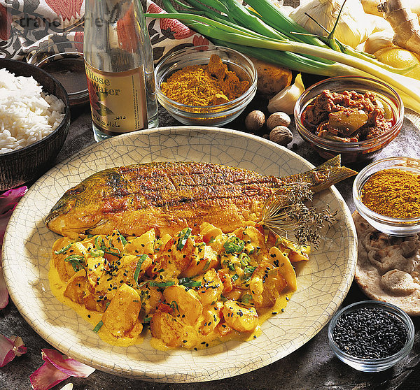 Curry-Kartoffeln  Bratkartoffeln fernöstlich gewürzt  mit feiner Joghurtsauce und schwarzem Sesam  Chili und Tomaten  Indien  Rezept gegen Gebühr erhältlich