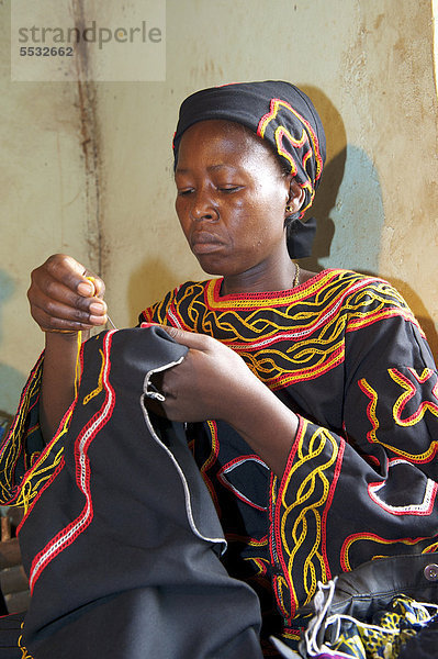 Frau im traditionellen Kleid bei Stickarbeiten  Bamenda  Kamerun  Afrika