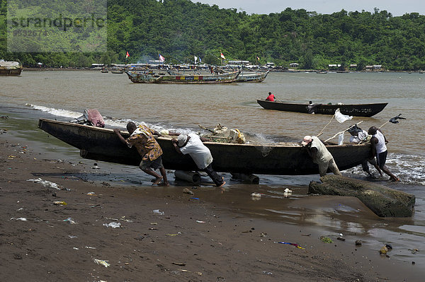 Fischer ziehen ein Boot an Land  Limbe  Kamerun  Afrika