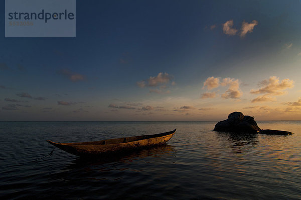 Ein traditionelles madagassisches Boot im Sonnenuntergang am Strand  Madagaskar  Afrika
