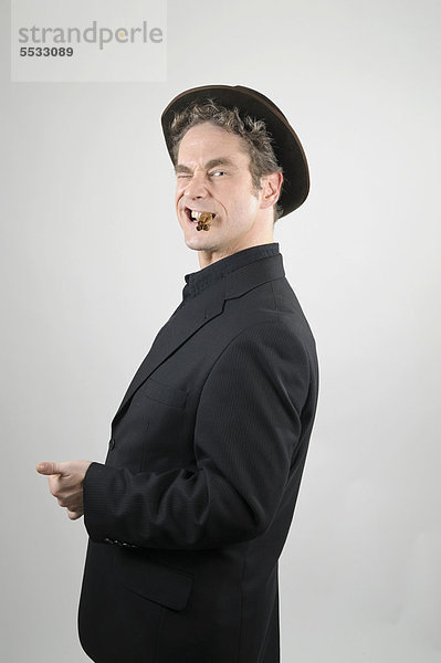 Geschäftsmann in schwarzem Anzug und Hut mit drei 3 inneinander gedrehten Zigarillos