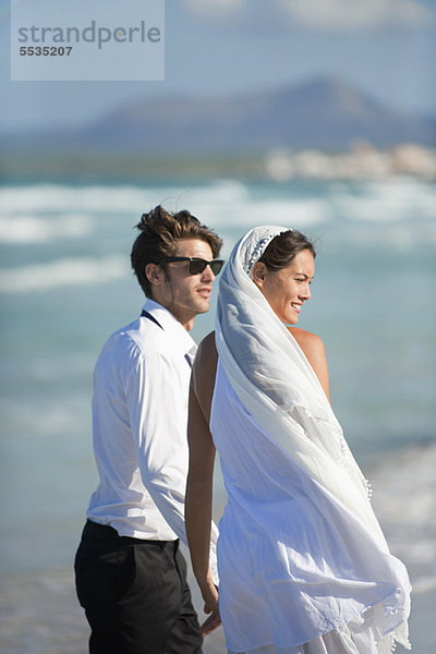 Braut und Bräutigam am Strand stehend  Blick auf die Aussicht