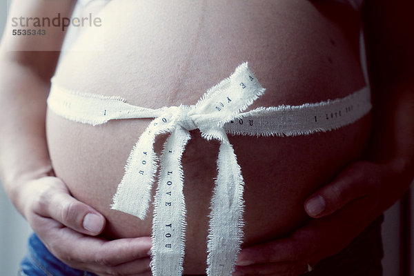Schwangere Frau mit Band um den Bauch  Mittelteil