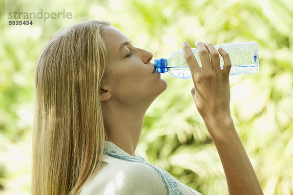 Frau trinkt Wasser in Flaschen