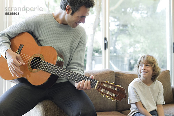 Vater spielt Gitarre für Sohn
