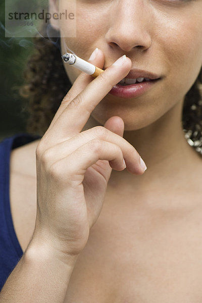 Junge Frau raucht Zigarette  abgeschnitten