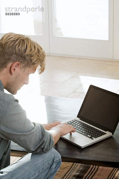 Mann mit Laptop-Computer zu Hause