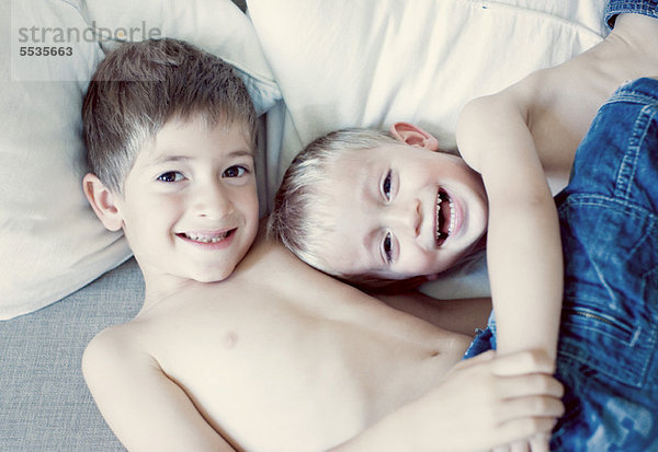 Junge Brüder auf dem Bett liegend  Porträt