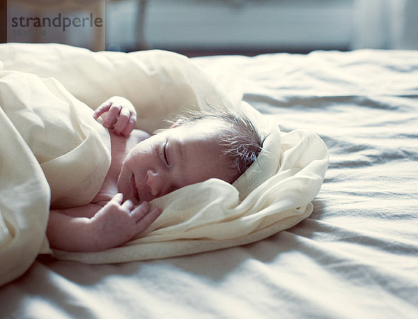 Neugeborenes Baby schläft im Bett