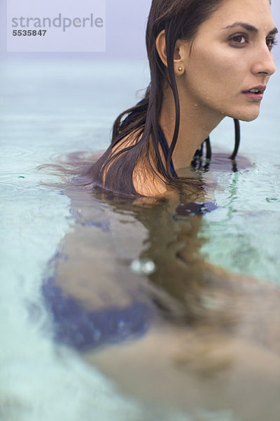 Frau im Wasser  wegblickend in Gedanken