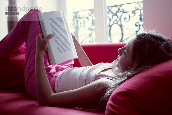 Mädchen-Lesebuch auf der Couch