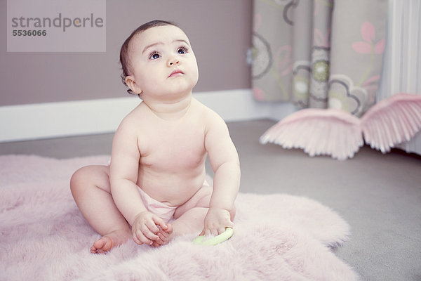 Baby sitzend auf Teppich  Portrait