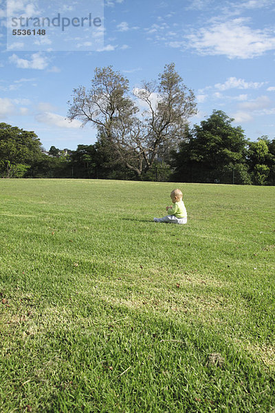Baby allein im Feld sitzend