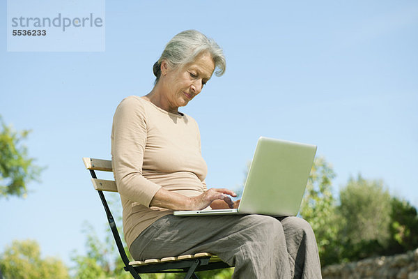 Senior Frau mit Laptop im Freien