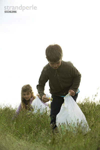 Kinder  die Müll auf dem Feld abholen