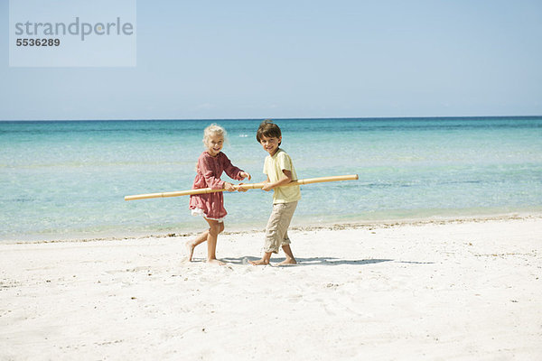 Junge und Mädchen halten sich am Strand zusammen.