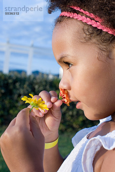 Kleines Mädchen riecht Blumen  Profil