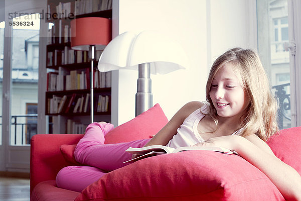 Mädchen entspannt auf der Couch Lesebuch