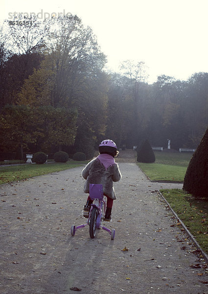 Kleines Mädchen auf dem Fahrrad  Rückansicht