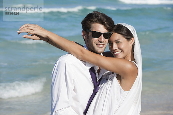 Braut und Bräutigam umarmend am Strand  Portrait