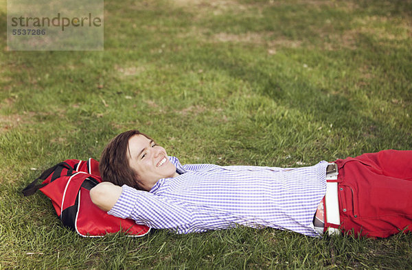 Lächelnder Teenager entspannt auf Gras