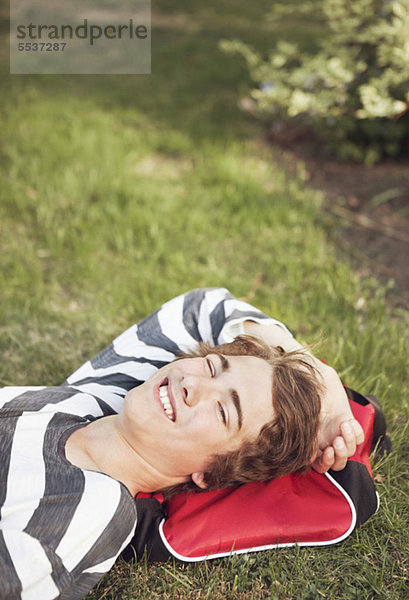 Fröhlicher Teenager entspannt auf Rasen