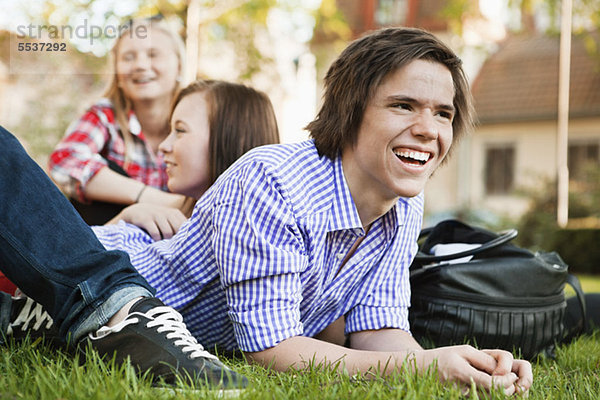 Fröhlicher Teenager lächelt und entspannt mit Freunden