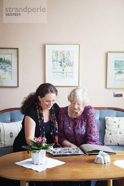 Glückliche Großmutter und Enkelin beim Betrachten des Fotoalbums