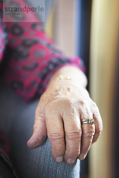 Nahaufnahme der faltigen Hand der Seniorin