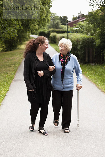 Zwei Frauen beim Spaziergang auf dem Fußgängerweg im Park