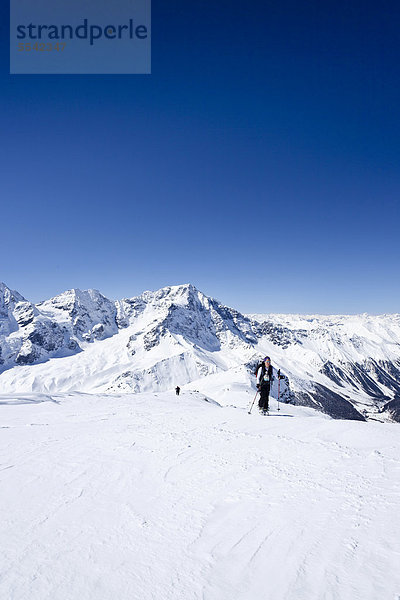Skitourengeher beim Aufstieg zur hinteren Schöntaufspitze  Sulden  hinten der Ortler und Zebru  Südtirol  Italien  Europa