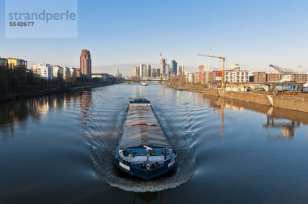 Skyline von Frankfurt mit dem Main Plaza Turm im linken Vordergrund und Lastkahn auf dem Main bei Morgenstimmung  Frankfurt am Main  Hessen  Deutschland  Europa