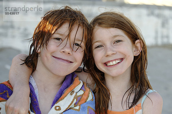 Bruder und Schwester mit nassen Haaren nach dem Schwimmen  lächelnd