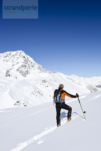 Skitourengeher beim Aufstieg zur hinteren Schöntaufspitze  Sulden  hinten der Ortler  Südtirol  Italien  Europa