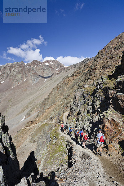 Wanderer beim Abstieg von der Similaunhütte im Schnalstal durch das Tisental  hinten die Finailspitze  Südtirol  Italien  Europa