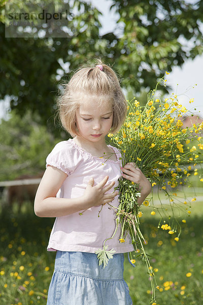 Mädchen mit Blumenstrauß auf einer Wiese