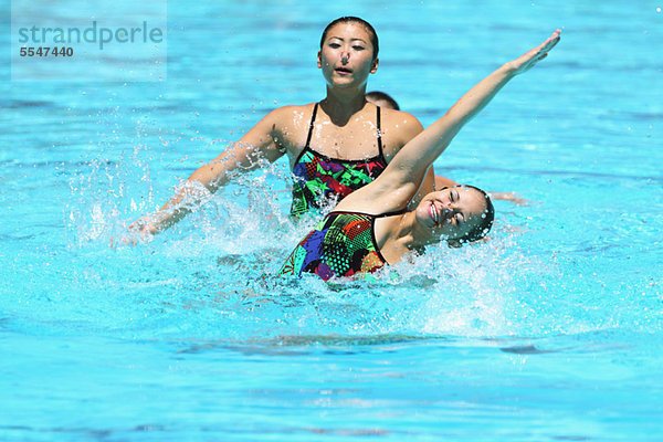 Swimmers Performing in Swimming Pool  Synchronized Swimming
