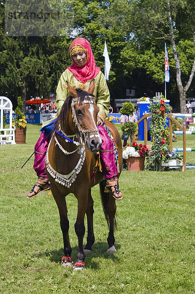 Reiterin der Royal Cavalry of Oman in leuchtender Uniform bei einer Showveranstaltung auf der Pferd International München  München  Bayern  Deutschland  Europa