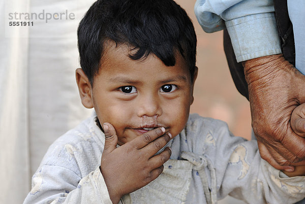 Kleiner Junge an der Hand eines Erwachsenen  Taumadhi-Platz  Bhaktapur  Kathmandu-Tal  Nepal  Asien