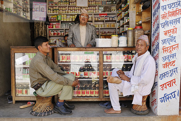 Männer sitzen vor Geschäft  Kathmandu  Nepal  Asien