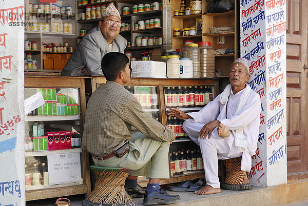 Männer sitzen vor Geschäft  Kathmandu  Nepal  Asien