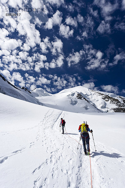 Bergsteiger beim Aufstieg zum Piz Palü durch die Gletscherlandschaft  hinten der Gipfel des Piz Palü  Graubünden  Schweiz  Europa