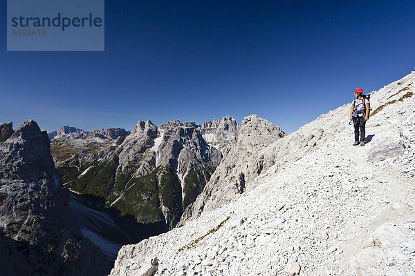 Wanderer im Alpinisteig  hinten die Dreischusterspitze  unten das Fischleintal  Sexten  Hochpustertal  Dolomiten  Südtirol  Italien  Europa