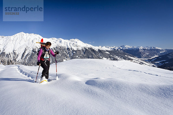 Schneeschuhwanderer beim Aufstieg zur Jagelealm im Ridnauntal oberhalb von Entholz  hinten die Ridnauntalm  der Rosskopf und die Telfer Weißen  Südtirol  Italien  Europa