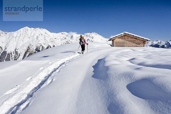 Schneeschuhwanderer beim Aufstieg zur Jagelealm im Ridnauntal oberhalb von Entholz  hinten der Rosskopf und die Telfer Weißen  Südtirol  Italien  Europa