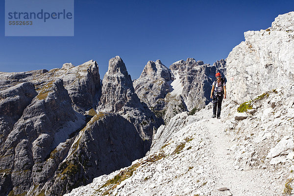 Wanderer im Alpinisteig am Einser  hinten die Dreischusterspitze  Sexten  Hochpustertal  Dolomiten  Südtirol  Italien  Europa